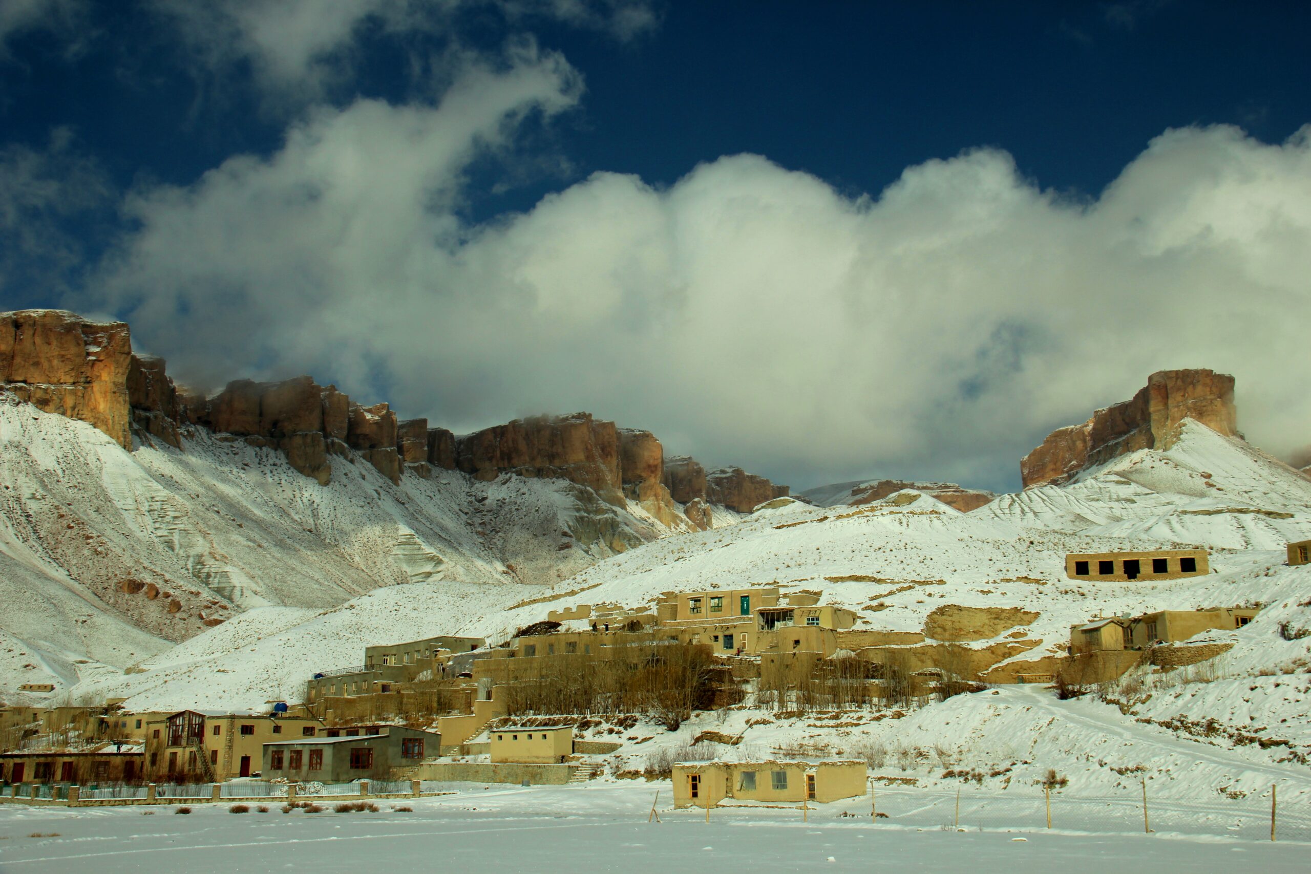 Photo of Sorobi Distrcit. Snow covers most of the small buildings. A huge cloud sits in the sky.