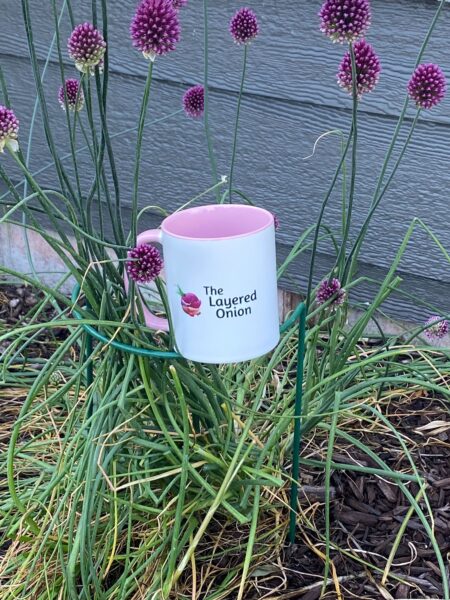 TLO logo on a pink mug in an allium plant