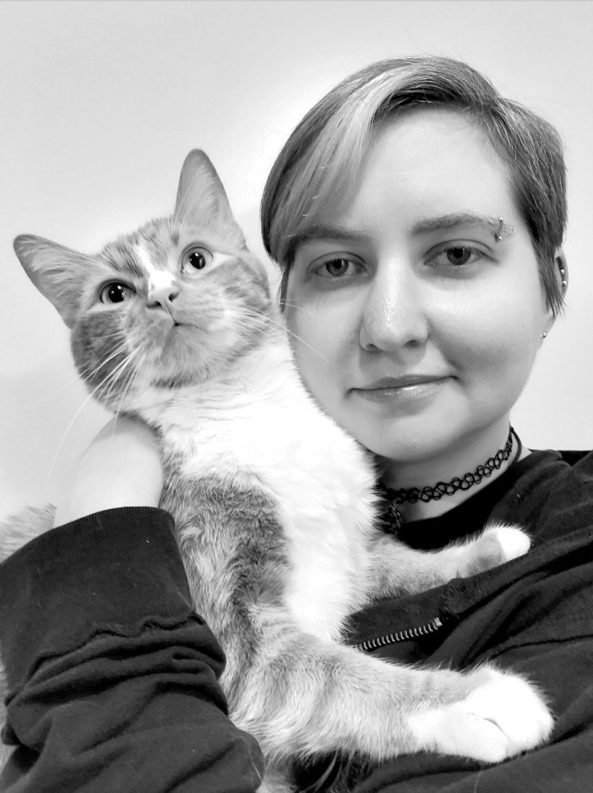 Black and white picture of Julie and her cat. Julie has short hair and an eyebrow piercing.